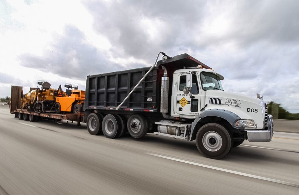 The Paving Lady truck pulling paving equipment